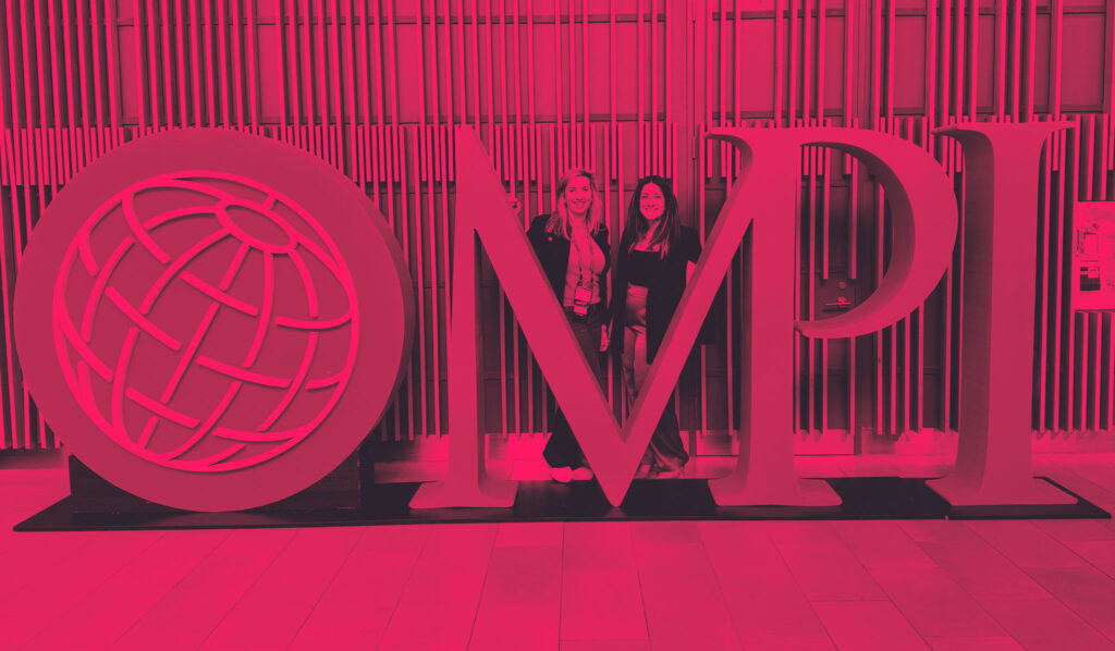 mya surrency and jaimie hart standing by a human size logo of MPI