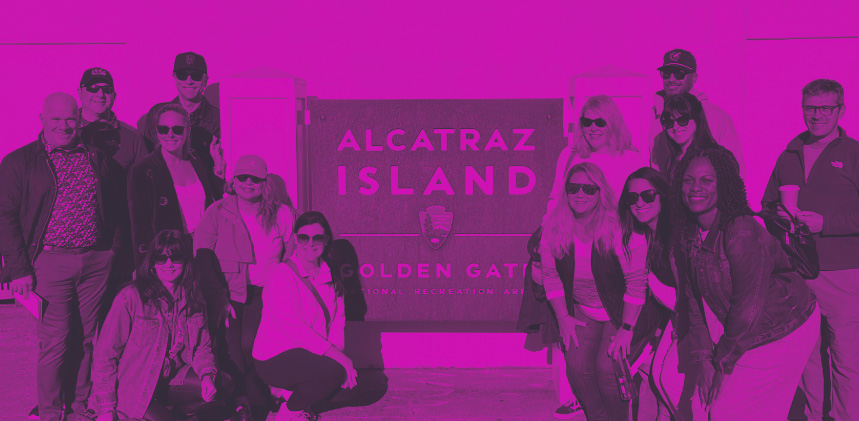 purple duotone image of business leaders at the convention infront of the alcatraz island sign