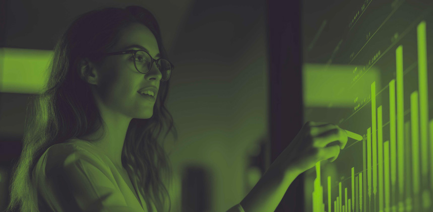 Green duotone image of a lady looking at a bar graph screen