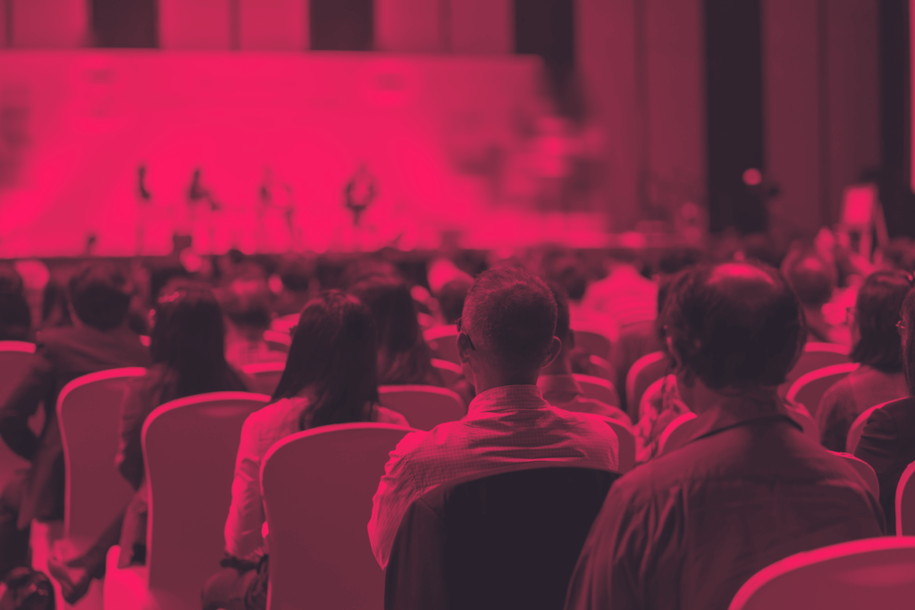 a crowd sitting at a convention panel talk